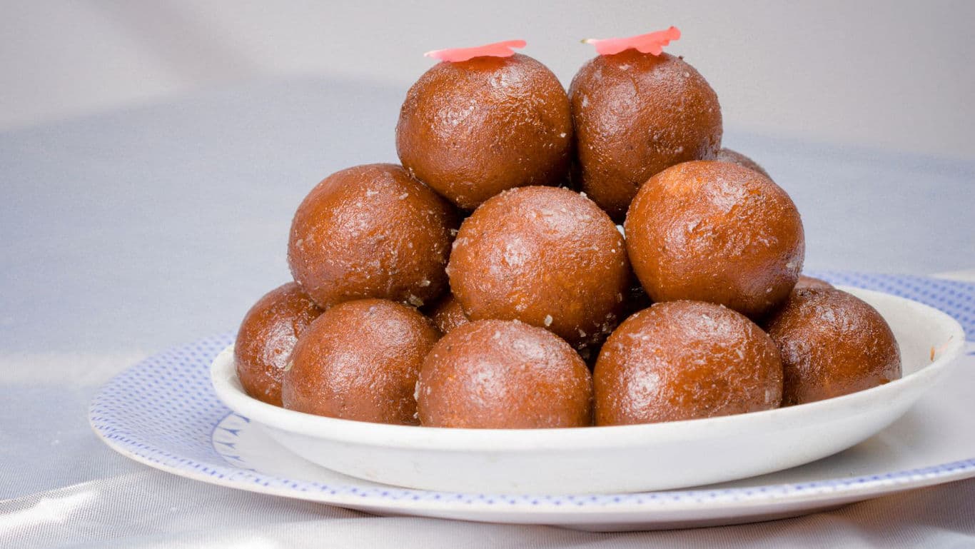 Stacked gulab jamuns on white plate