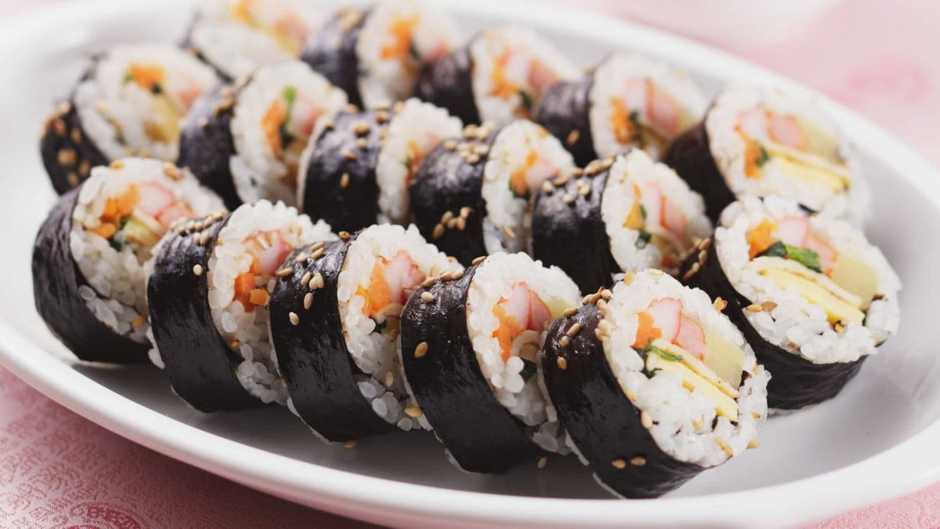 Assorted Kimbap Rolls Arranged on White Plate