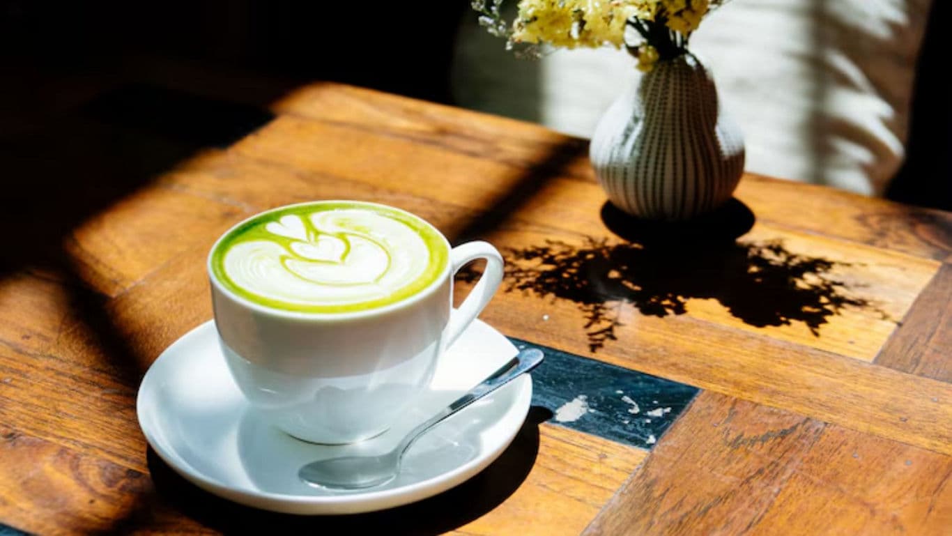 Matcha latte on wooden table with sunlight