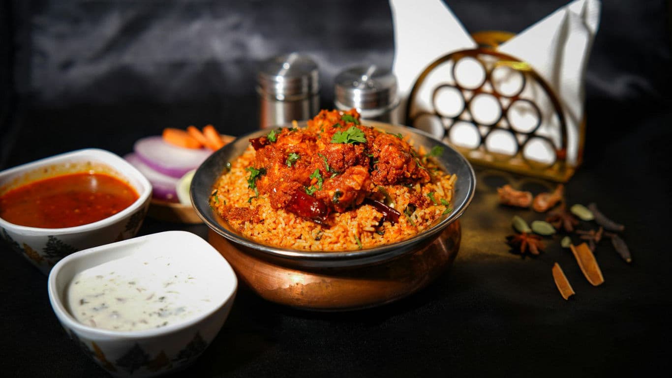 Spicy biryani with side dishes and spices