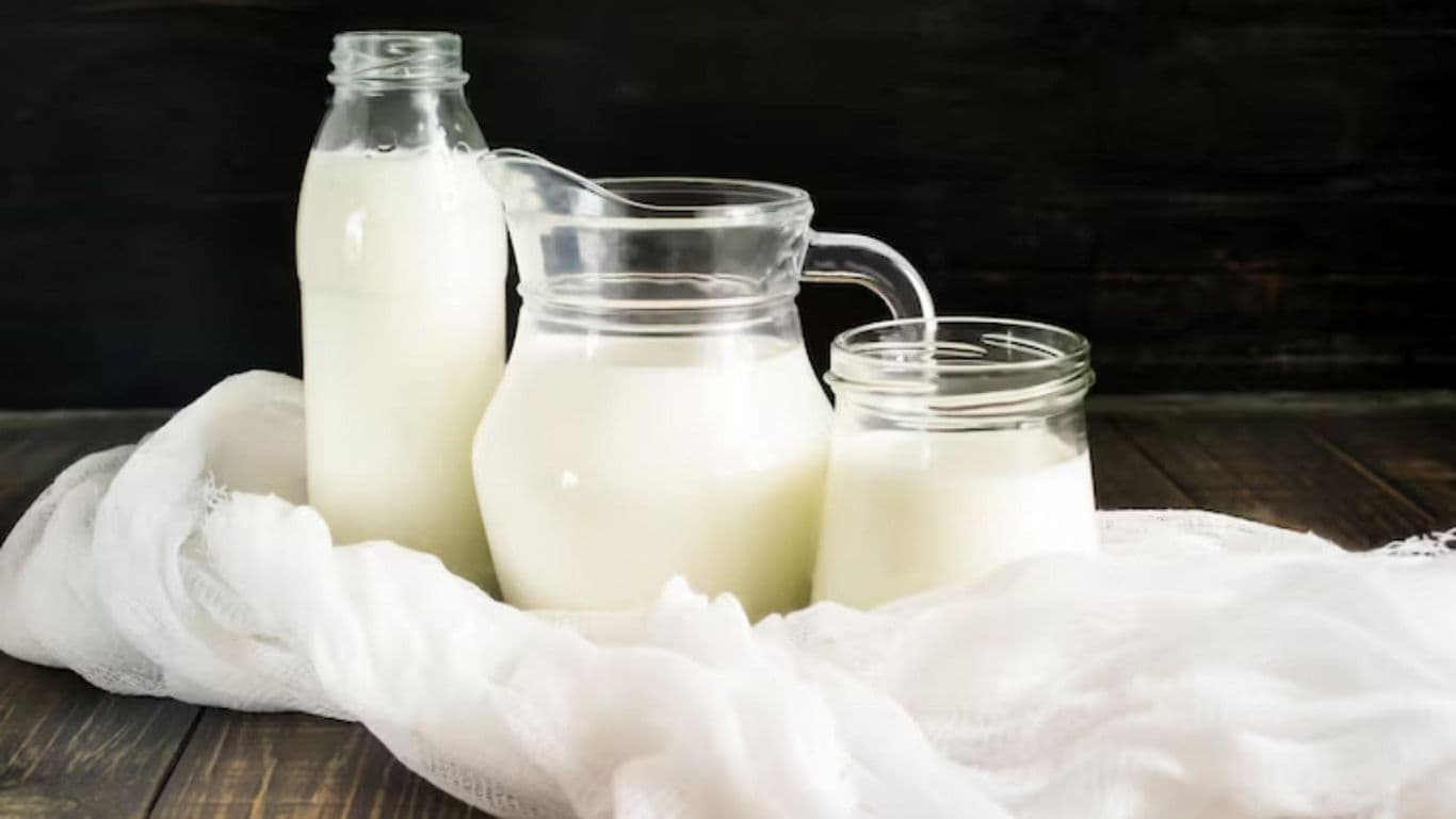 Glass containers with fresh milk on table