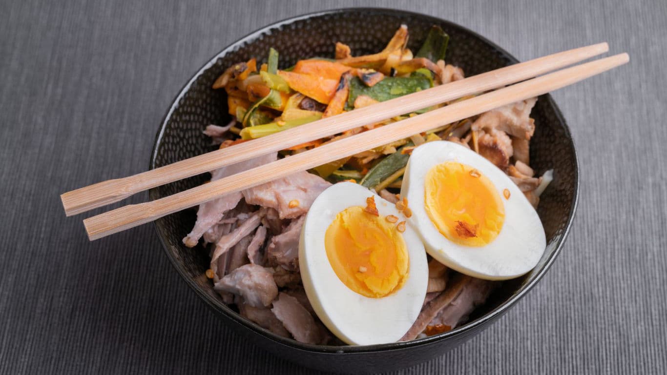 Bowl of ramen with egg and chopsticks