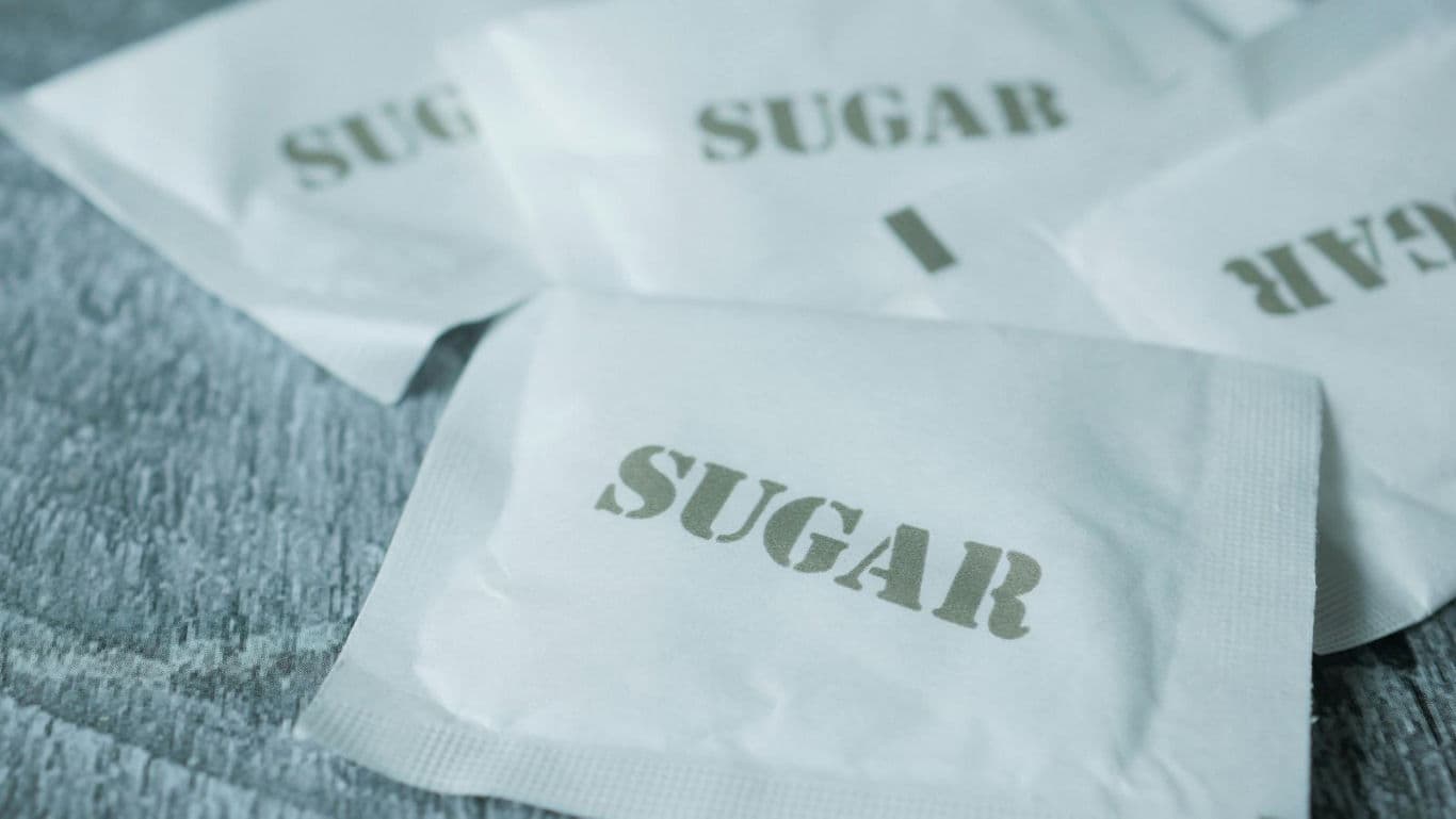 White sugar packets on textured surface