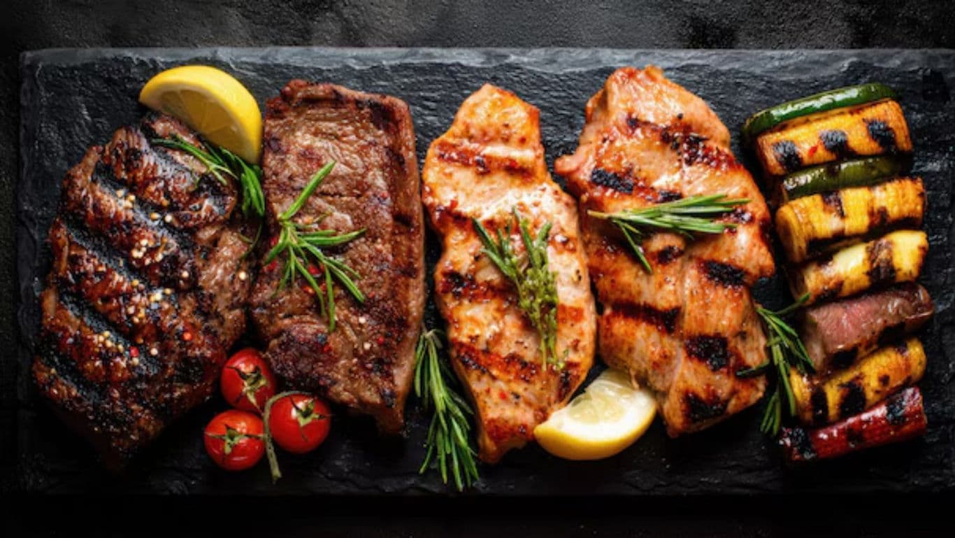 Assorted grilled meats and vegetables on slate
