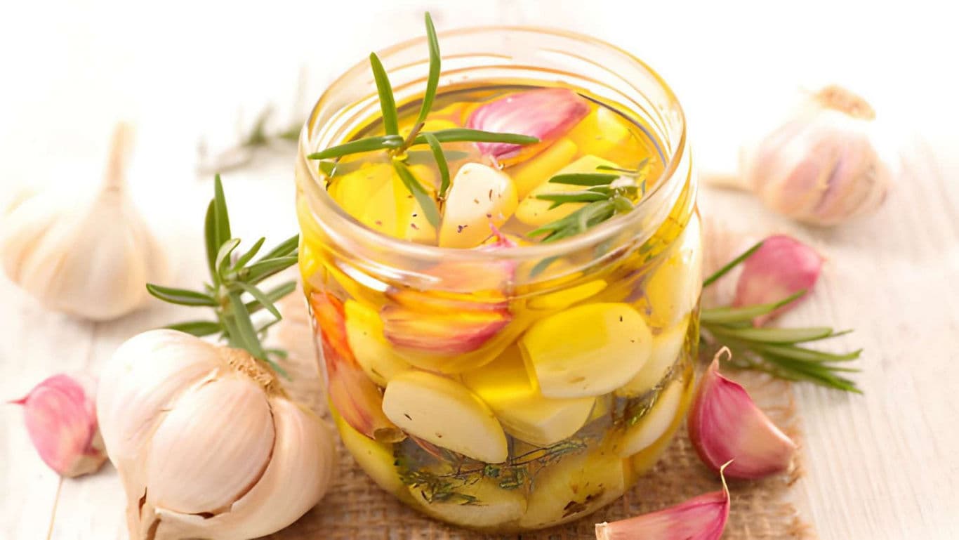 Jar of marinated garlic with herbs