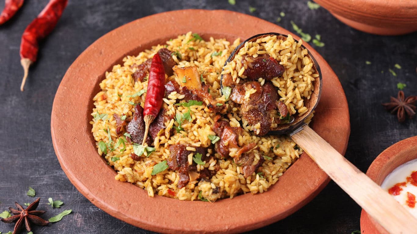 Spicy meat biryani in clay bowl