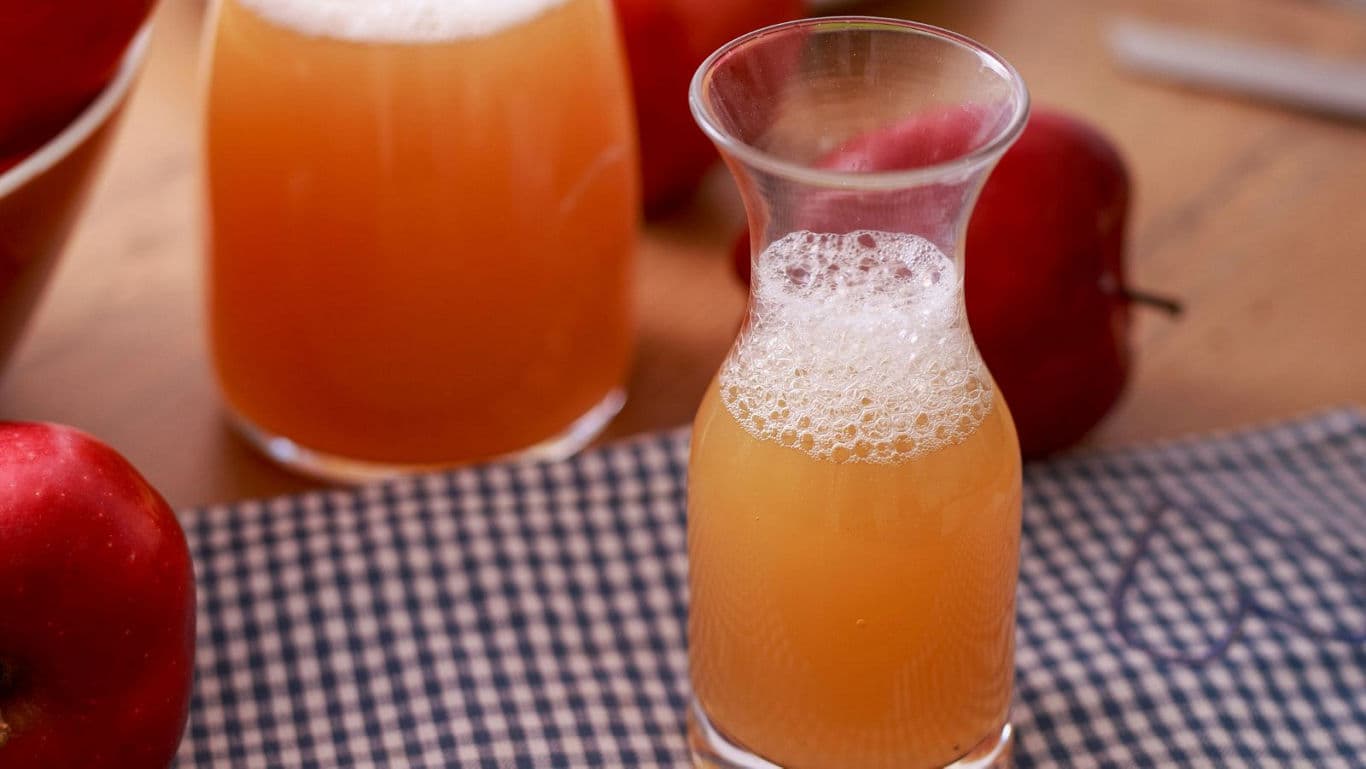 Fresh apple juice in glass carafe and tumbler