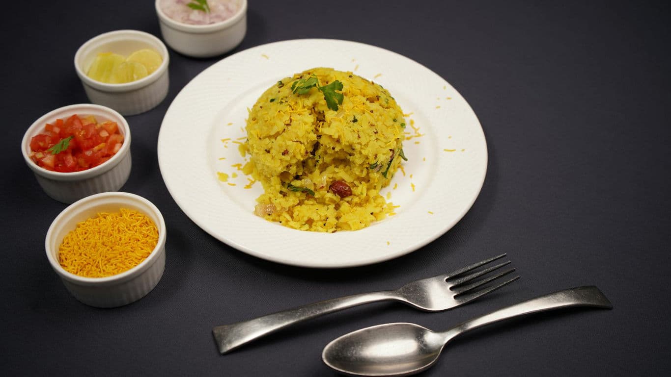 Plate of poha with side condiments