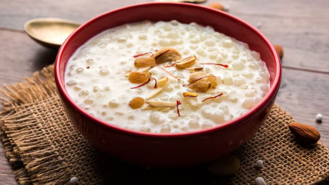 Creamy dessert with almonds in red bowl