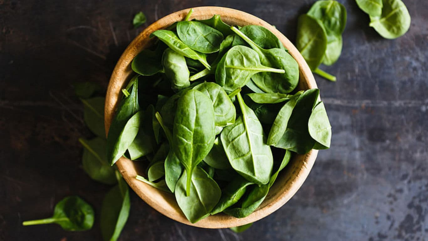 Fresh spinach leaves in wooden bowl