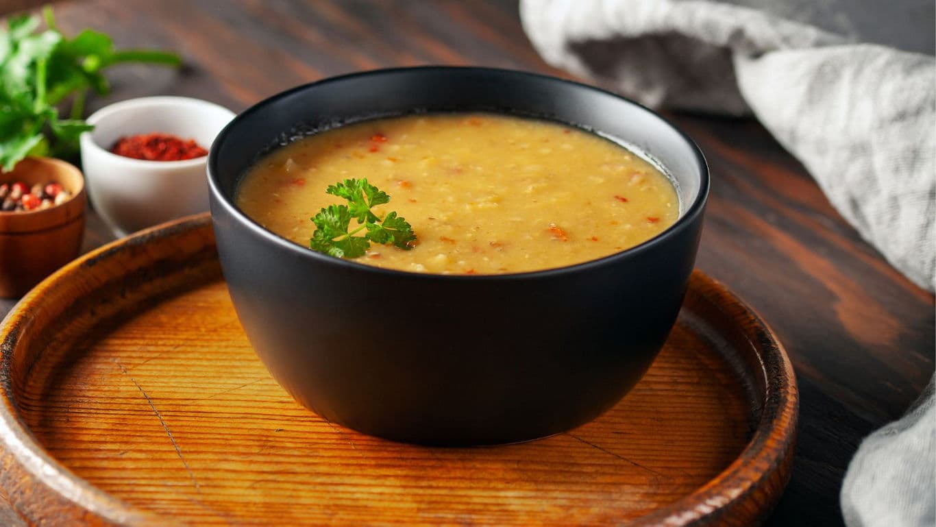 Bowl of hearty lentil soup on wooden tray