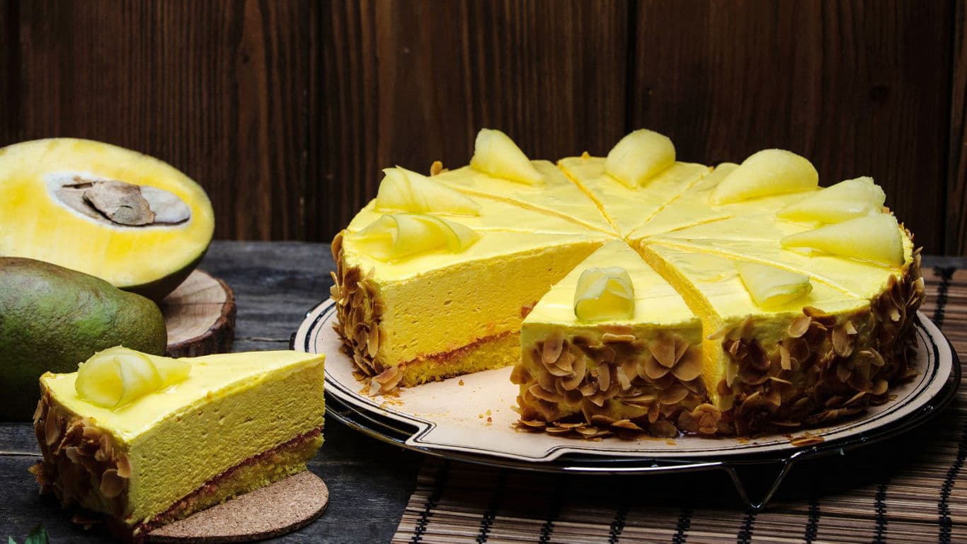 Yellow cheesecake topped with mango buttercream, a festive Bengali dessert.