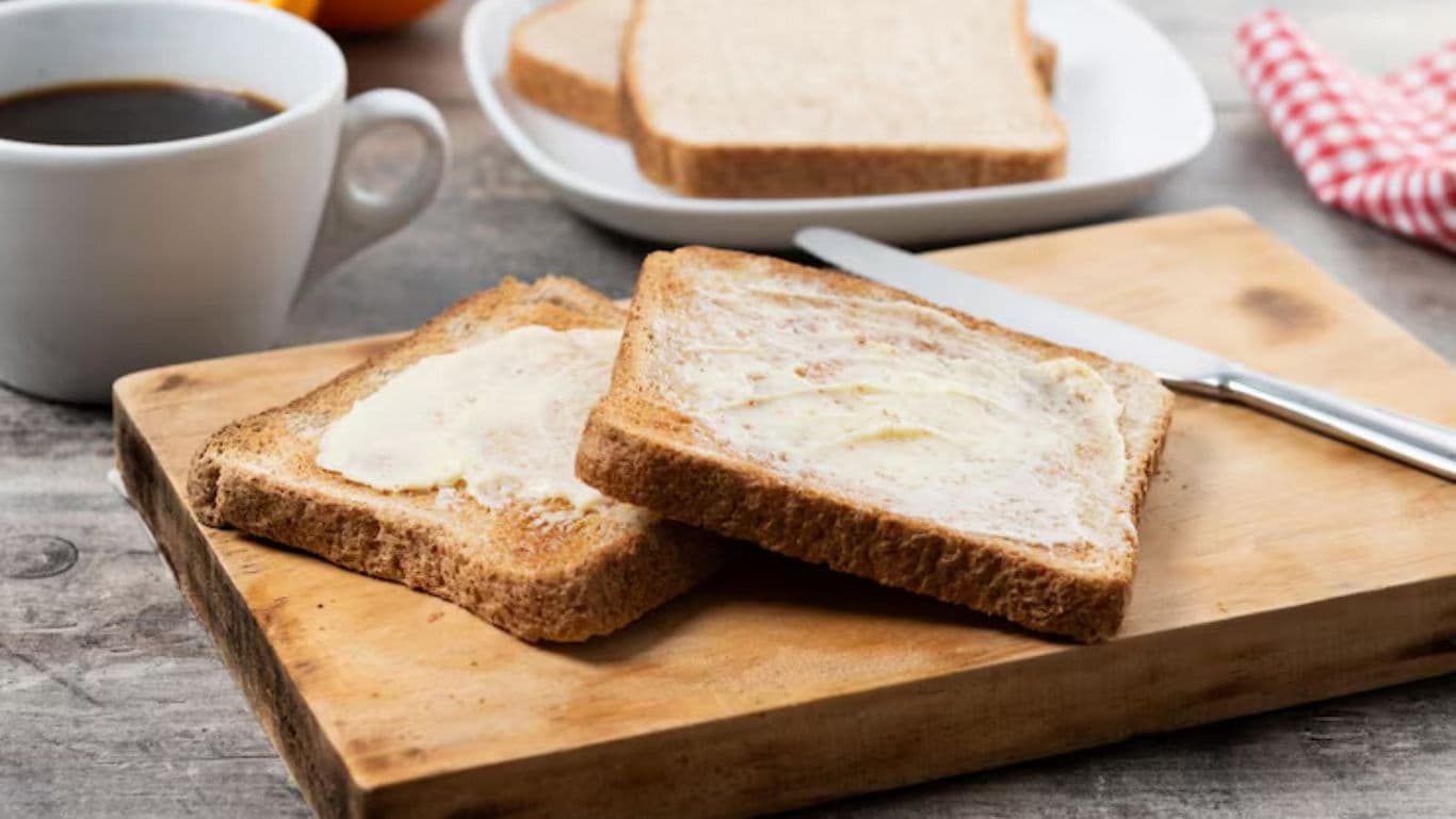 Toasted bread with butter on wooden board