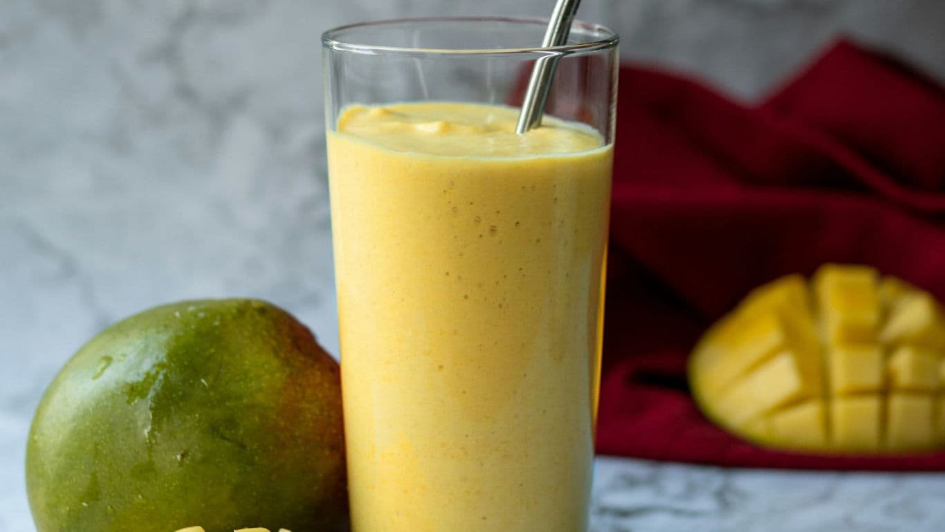 Fresh Mango Smoothie in Tall Glass with Straw