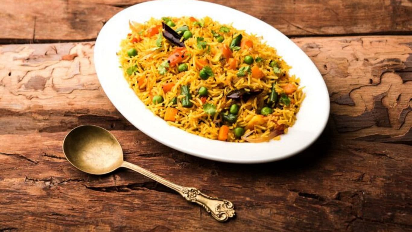 Vegetable rice pilaf served on rustic wooden table