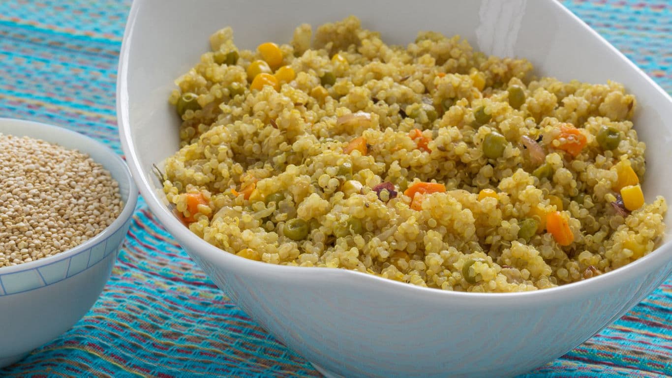 Cooked quinoa with vegetables in white bowl