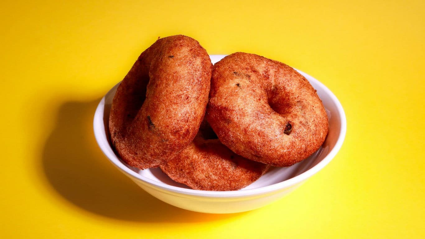 Golden brown donuts in white bowl