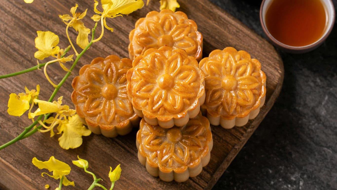Golden mooncakes with tea and flowers
