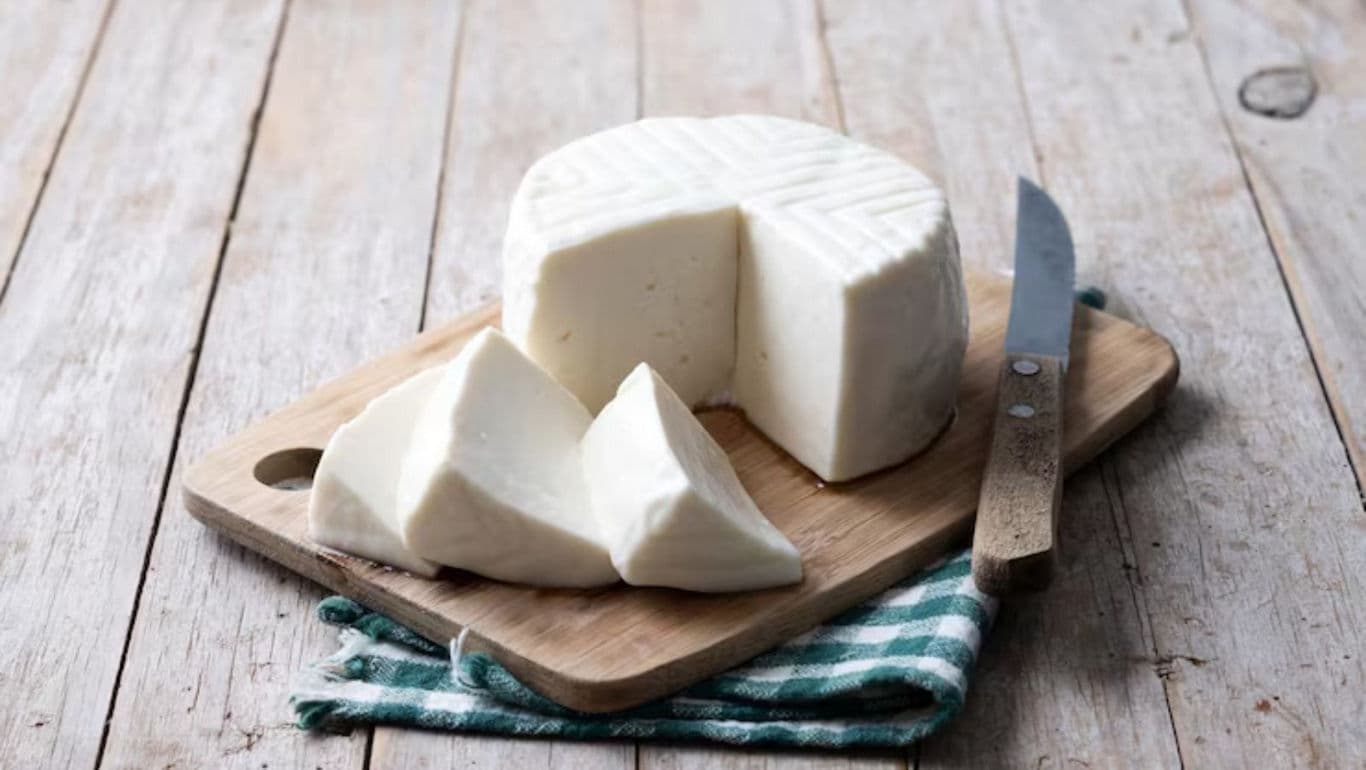 Fresh white cheese on wooden board
