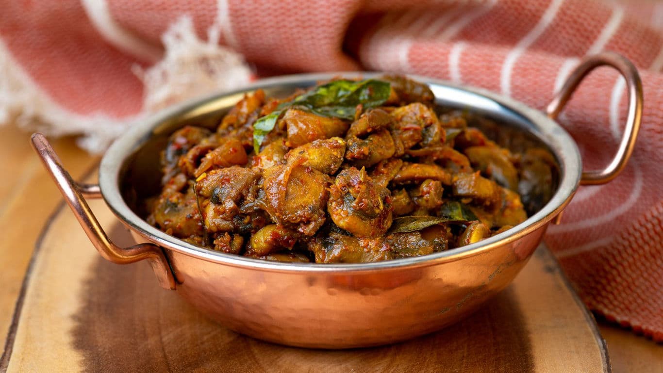 Spiced mushroom curry in copper bowl