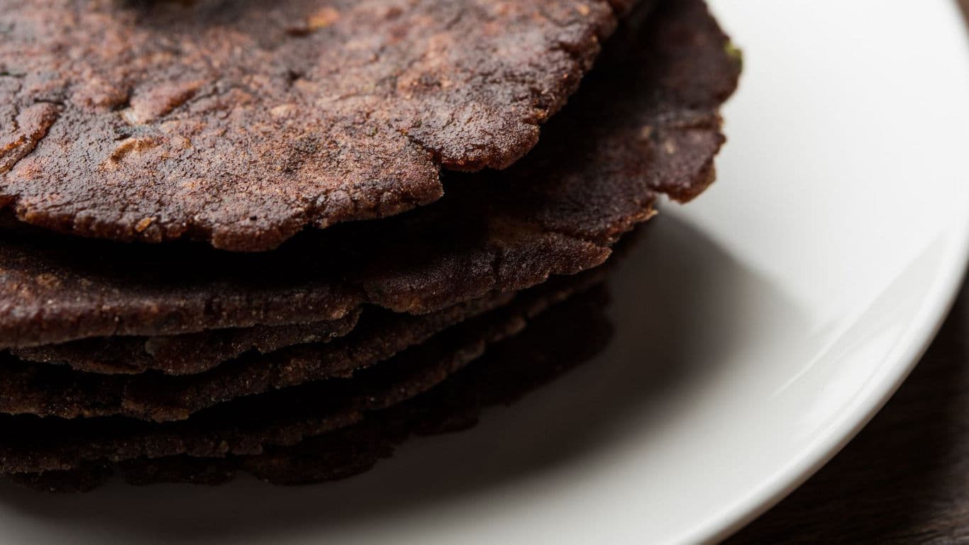 Stack of Dark Flatbreads on White Plate