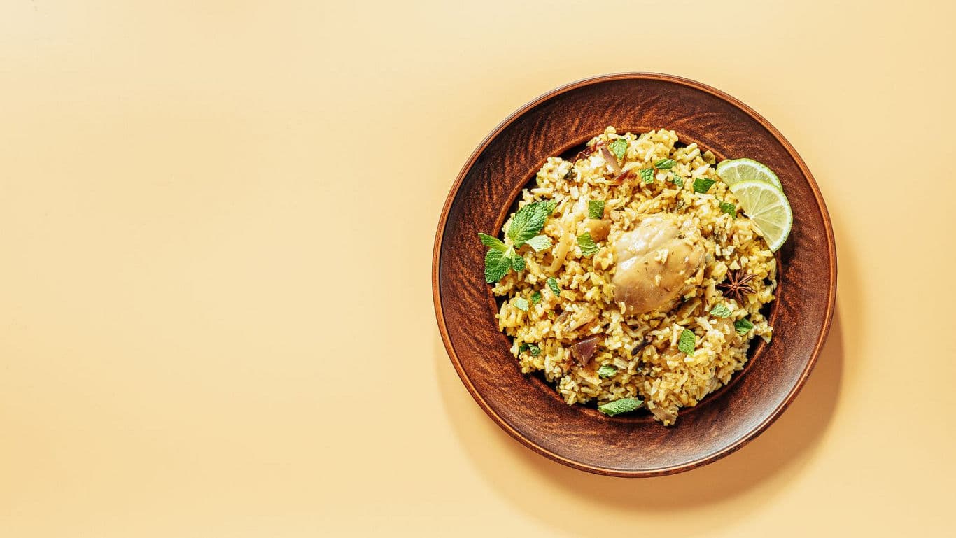 Chicken biryani with lime garnish