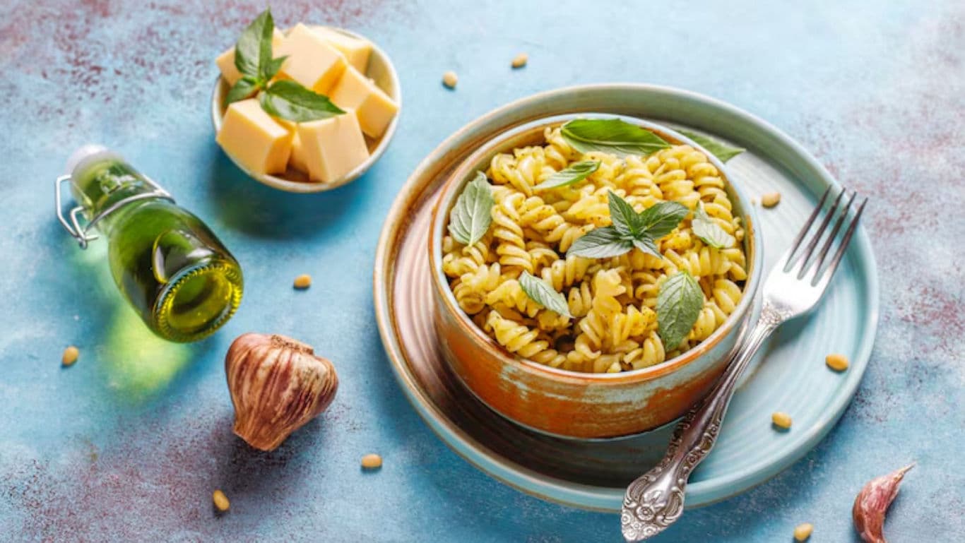 Fusilli pasta with pesto sauce and fresh basil leaves