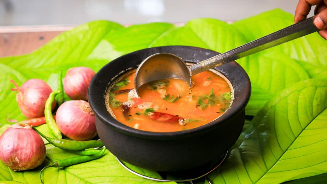 Traditional soup in black bowl on leaves