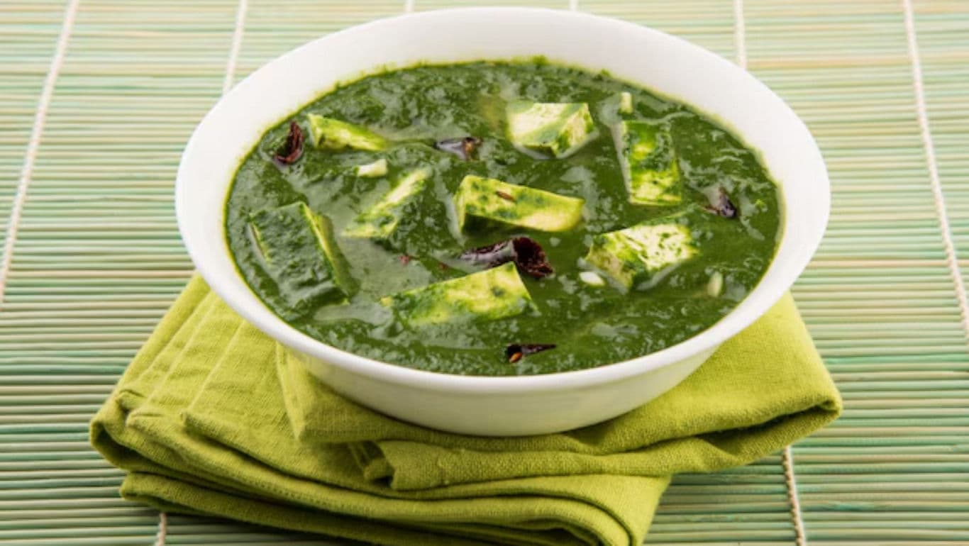 Bowl of palak paneer on green napkin background