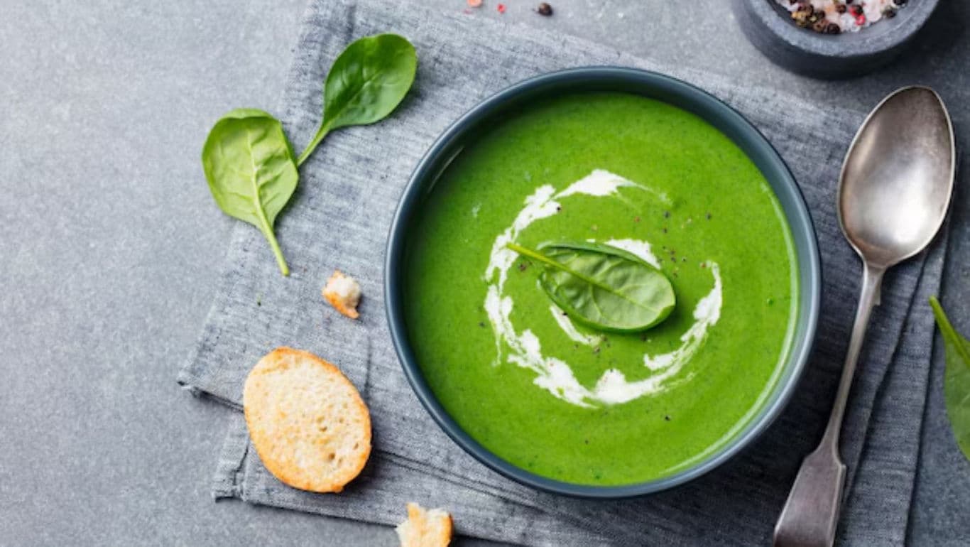 Fresh spinach soup with bread slices