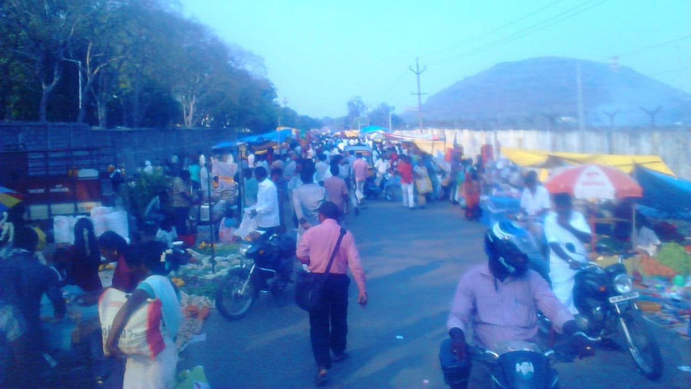 Busy outdoor market with shoppers and vendors