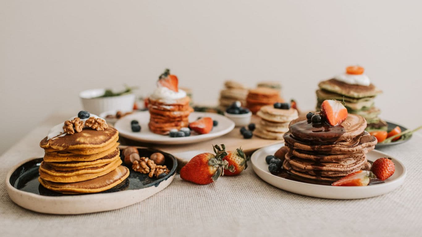 Assorted pancake stacks with fruits and nuts