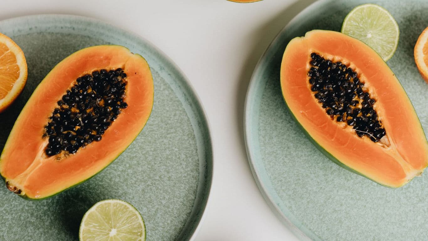 Fresh papaya halves with citrus slices on plates