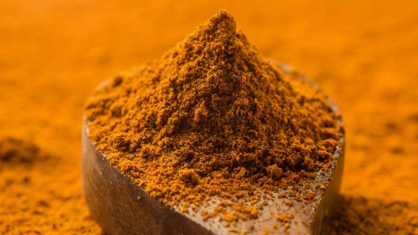 Wooden spoon with ground turmeric powder