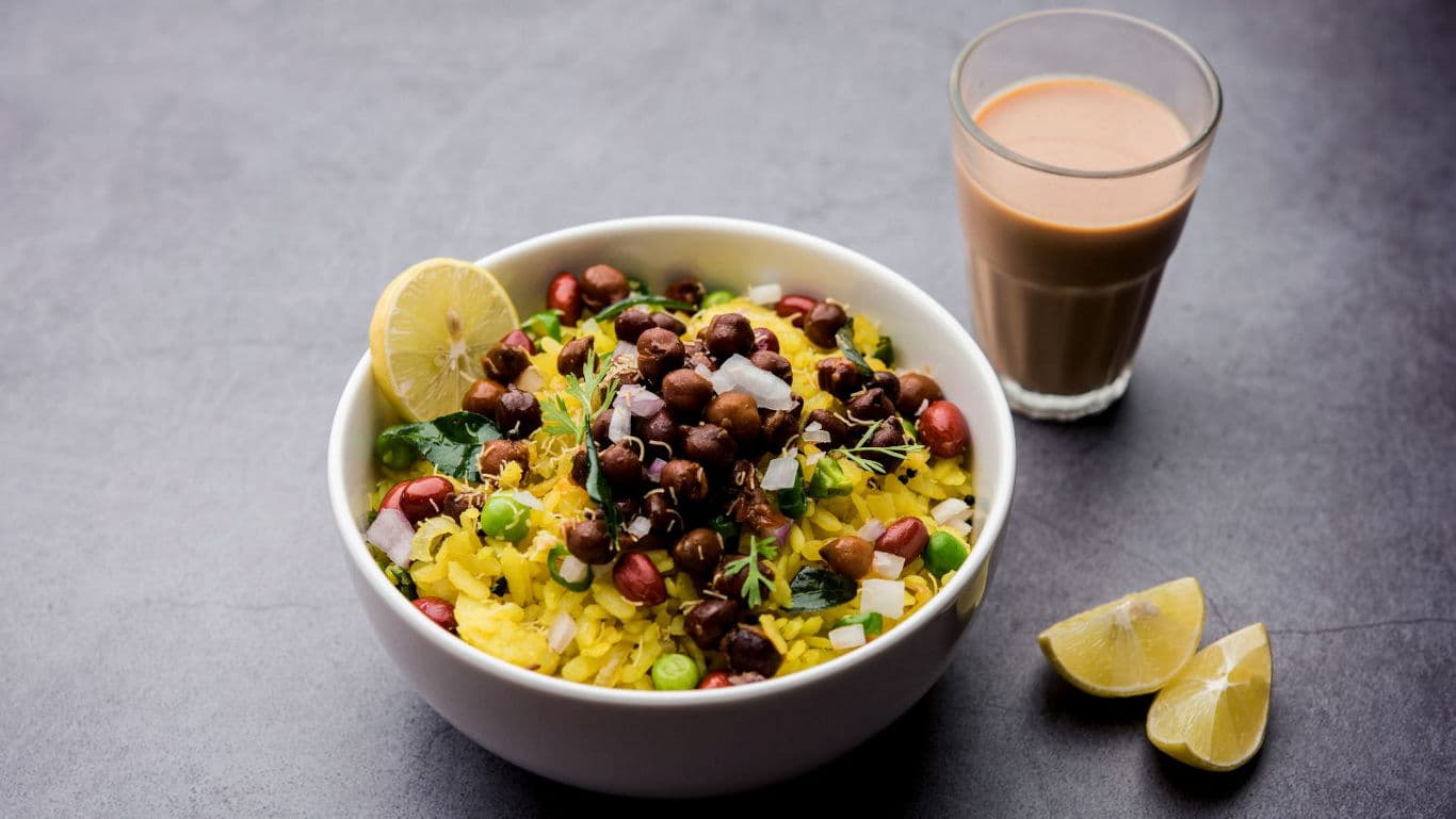 Indian poha with tea and lemon wedges