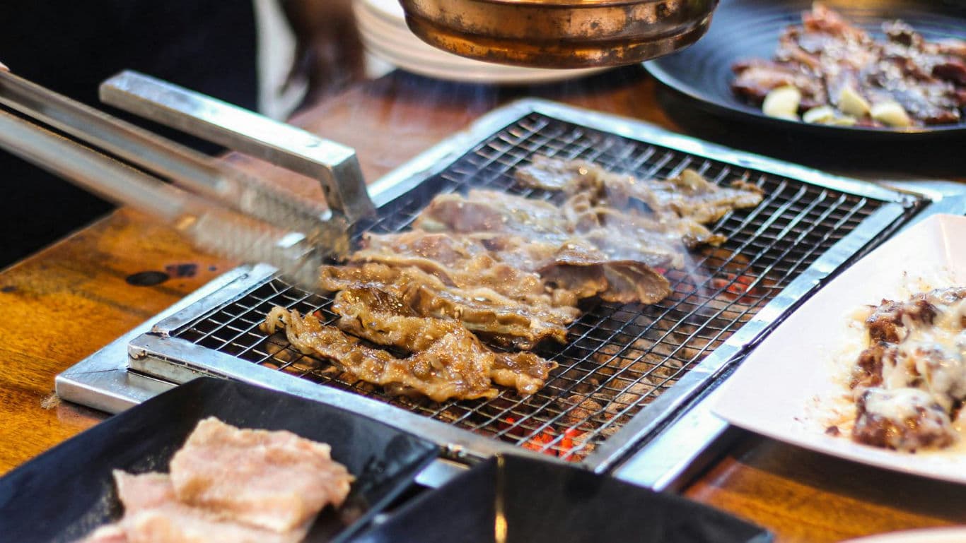 Grilled meat cooking on tabletop barbecue grill