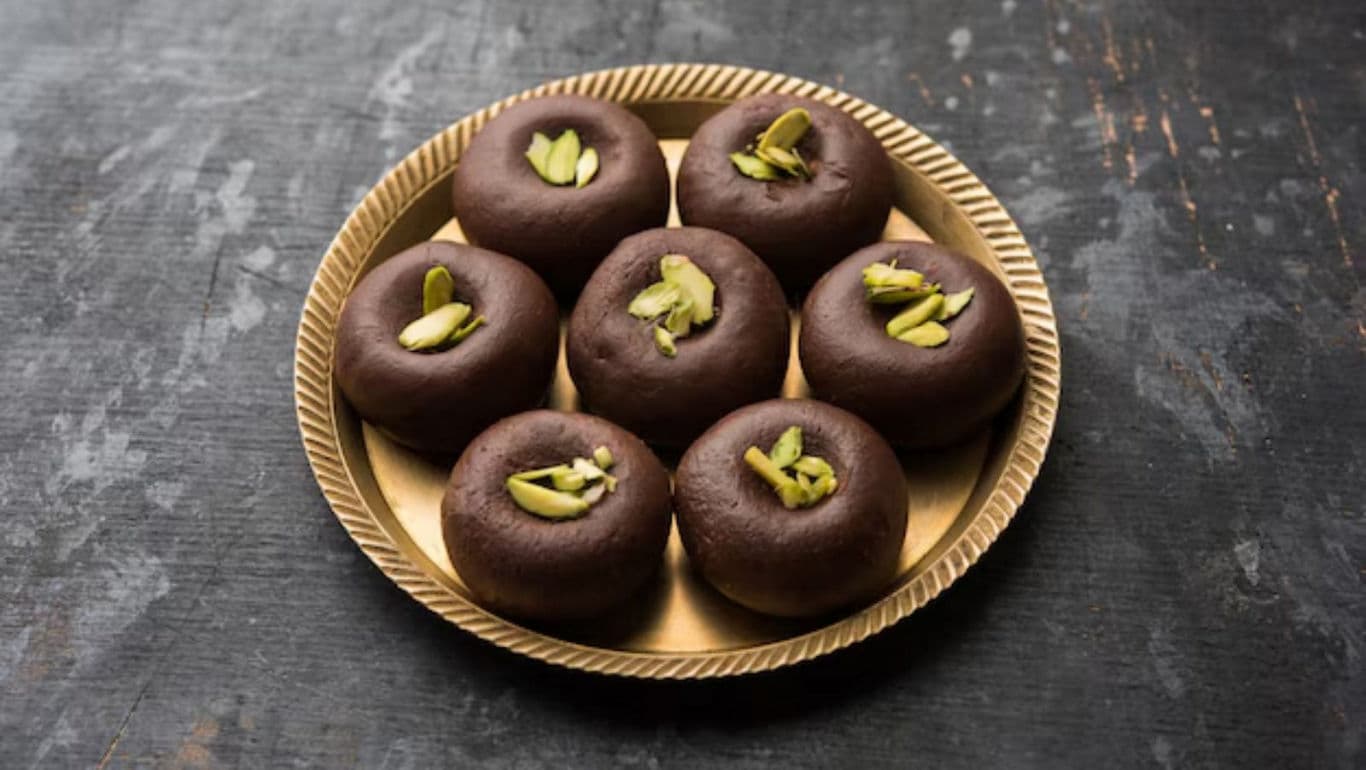 Chocolate peda sweets garnished with pistachios on tray