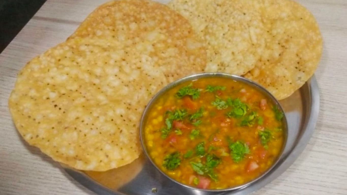 Crispy papad with lentil curry served