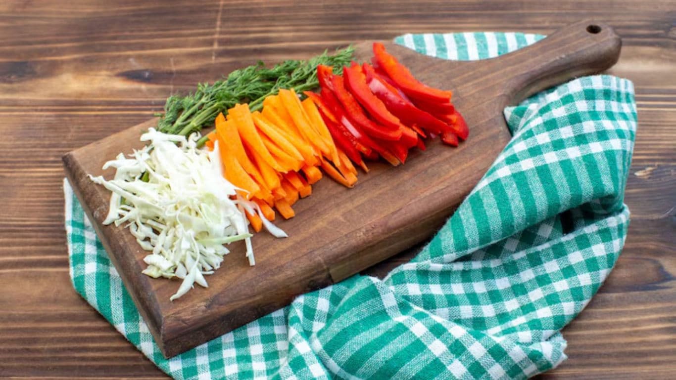 Fresh sliced vegetables on wooden cutting board