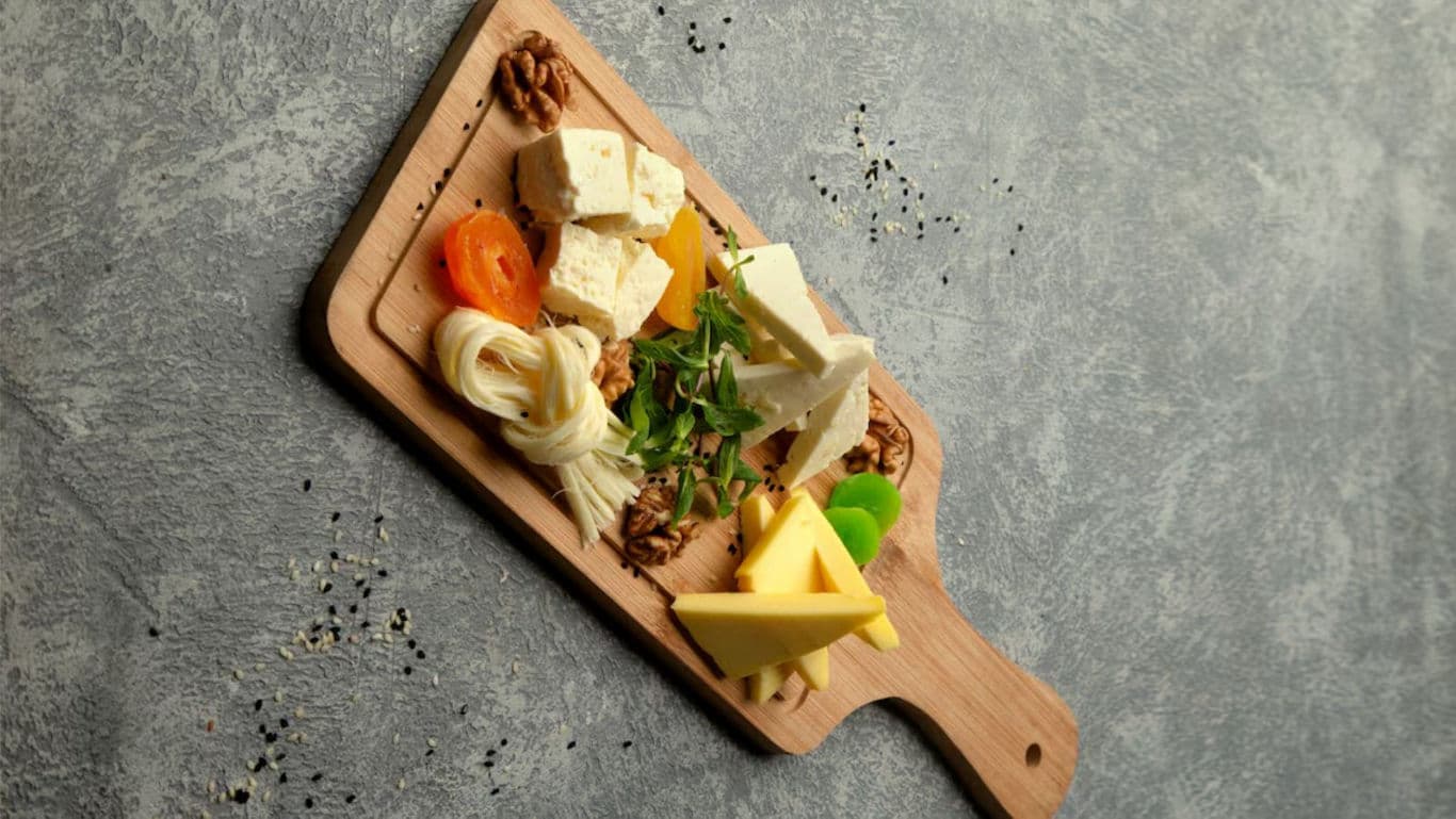 Cheese and nuts platter on wooden board