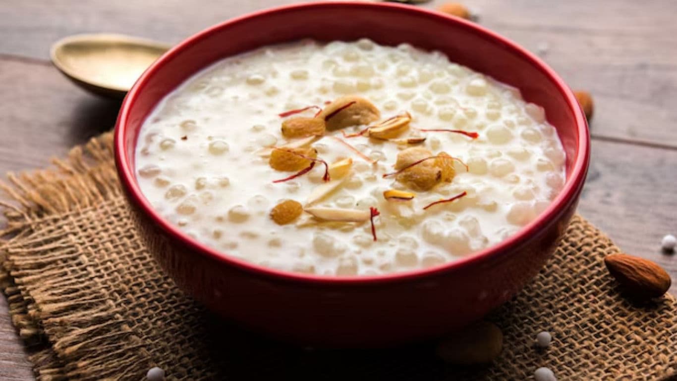 Creamy dessert with almonds in red bowl