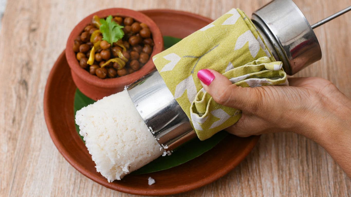 Hand pressing rice with traditional tool