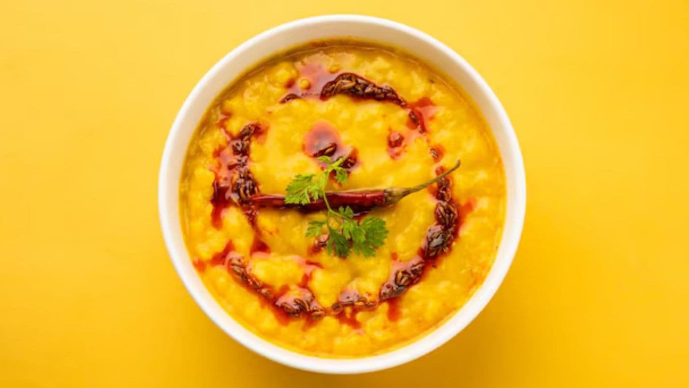 Bowl of spiced lentil curry on yellow