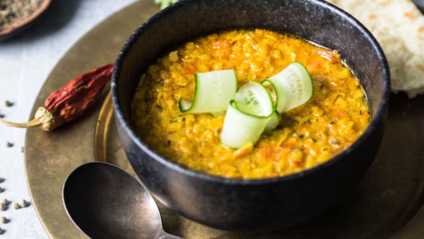 Bowl of lentil curry with cucumber garnish