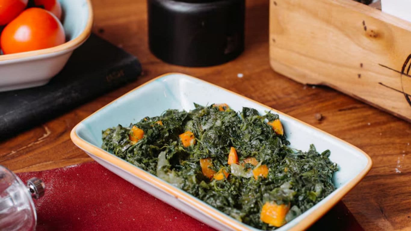 Cooked spinach and vegetables in ceramic dish