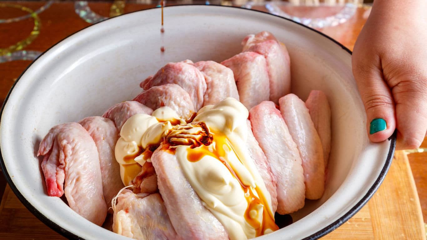 Raw Chicken Wings with Mayonnaise and Sauce in Bowl