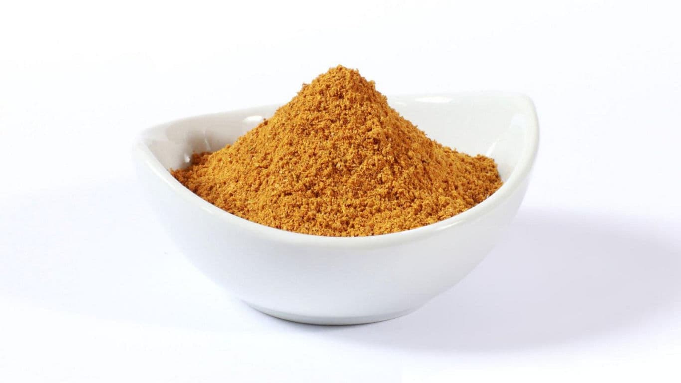 Bowl of ground spice on white background
