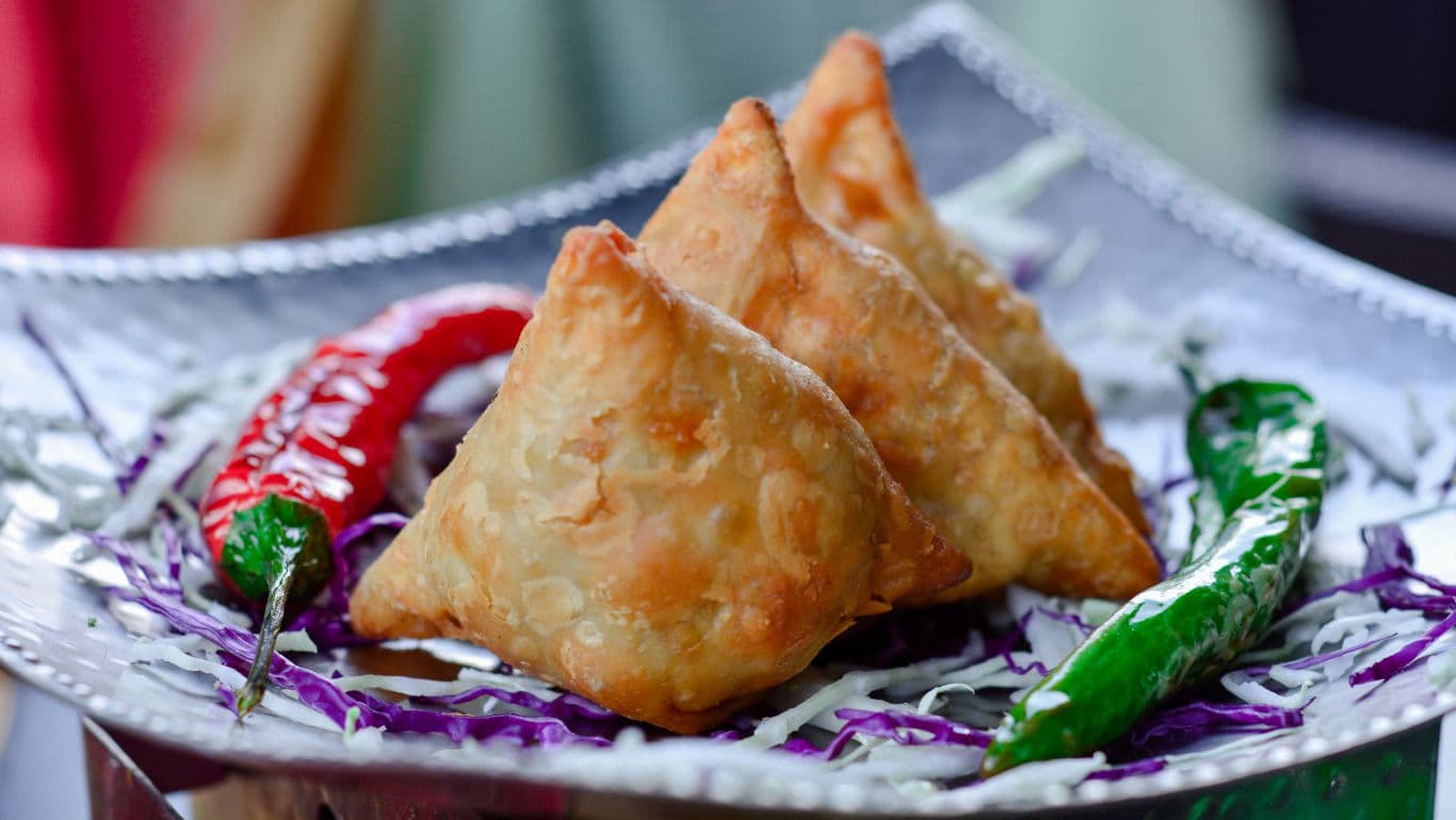 Crispy samosas with chili garnish