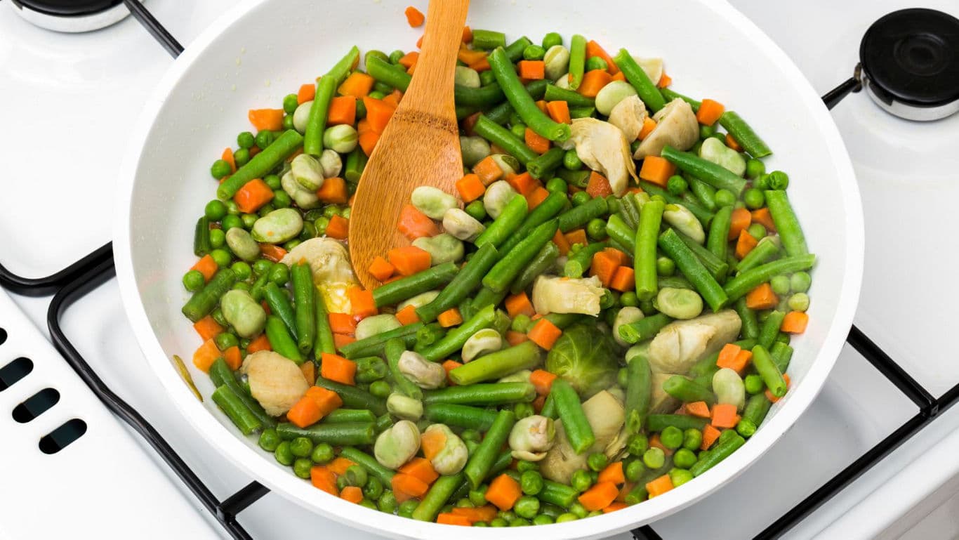 Mixed vegetables cooking in white pan