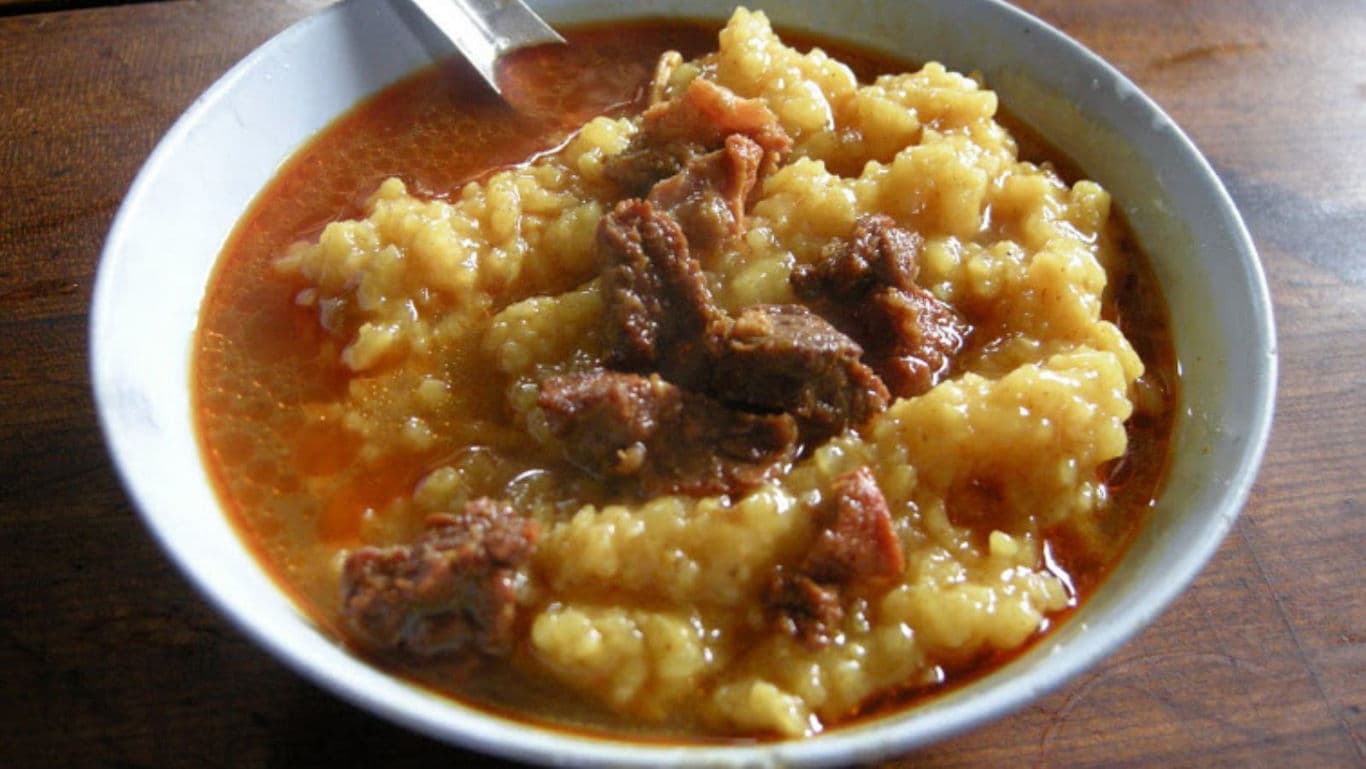 Hearty meat stew with dumplings in bowl